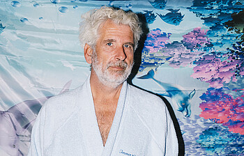 Portrait eines Mannes, der einen weißen Bademantel trägt.