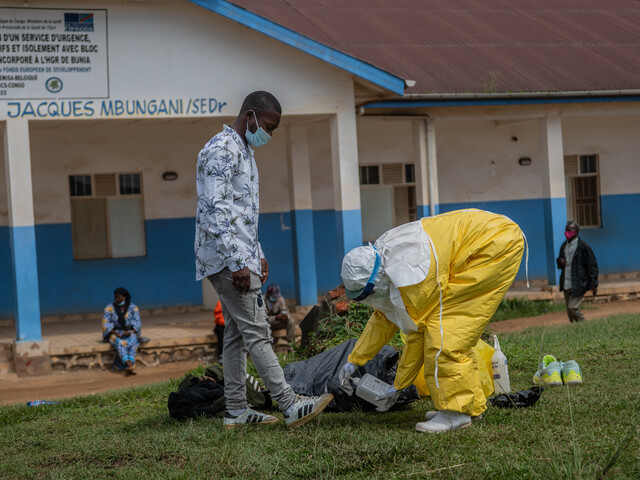 Person in Schutzanzug desinfiziert Ausrüstung vor Klinik in der DR Kongo während eines Ebola-Ausbruchs.