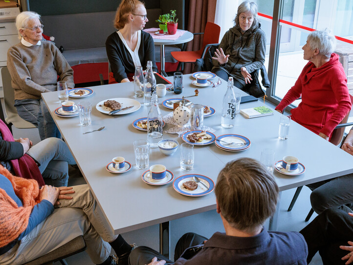 Angehörige sitzen mit Kaffee und Kuchen bei einem Angehörigencafé zusammen.