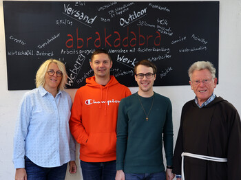 Eine Frau und drei Männer, einer davon Priester, stehen vor einer Tafel mit der Aufschrift "abrakadabra".
