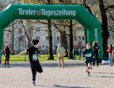 Zwei Schüler laufen vor einem Werbebogen der Tiroler Tageszeitung.