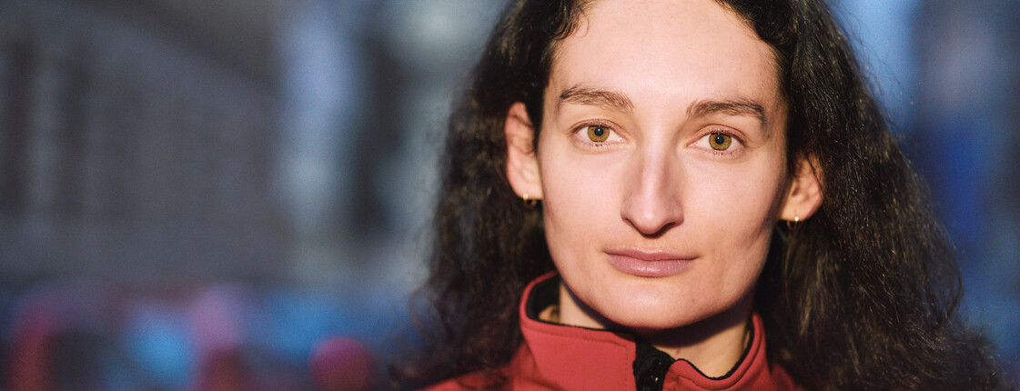 Portrait einer Frau mit einer roten Jacke.