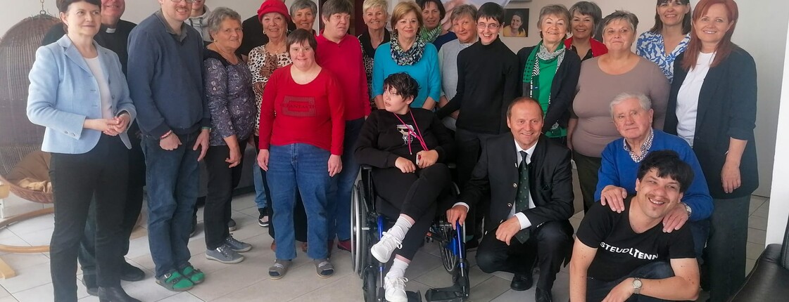 Gruppenfoto von Bewohner*innen einer Tagesstätte sowie LHStv. Josef Geisler, Caritas Direktorin Elisabeth Rathgeb, Dienststellenleiterin Barbara Kainzner-Abendstein und Pfarrer Erwin Gerst. 