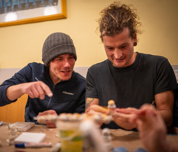 Zwei Männer haben Spaß beim gemeinsamen Auspacken der Geschenke.