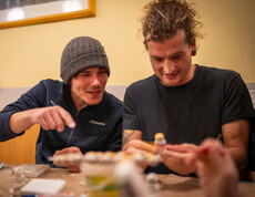 Zwei Männer haben Spaß beim gemeinsamen Auspacken der Geschenke.