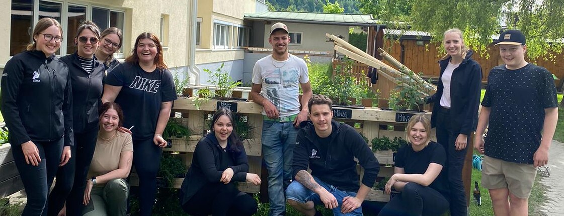 Ein Gruppenfoto von elf Personen in einem Garten.