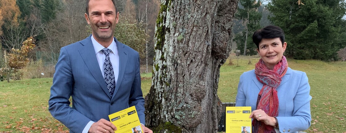 Ein Mann und eine Frau präsentieren eine Broschüre