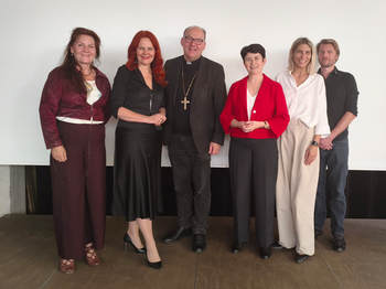 Sechs Personen stehen vor einer weißen Wand zu einem Gruppenfoto zusammen.