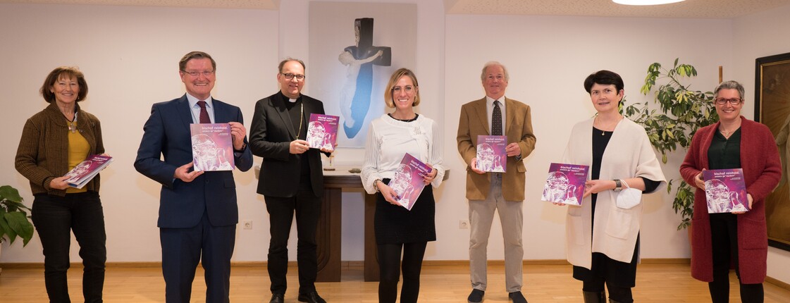Sieben Personen stehen zu einem Gruppenfoto zusammen.