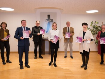Sieben Personen stehen zu einem Gruppenfoto zusammen.