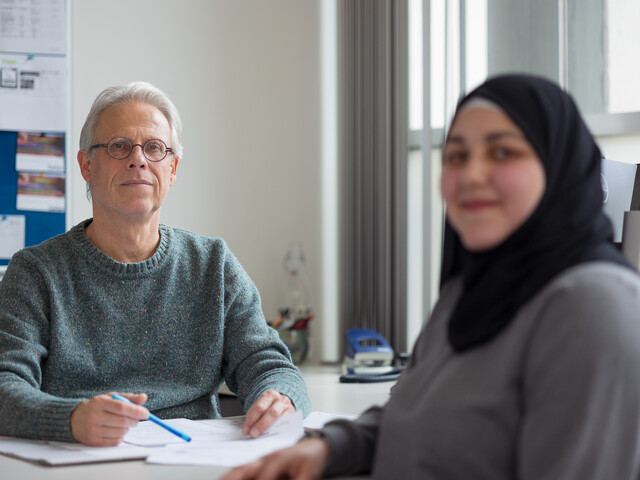 Portrait eines Caritas Mitarbeiters der Flüchtlingsberatung während eines Beratungsgesprächs.