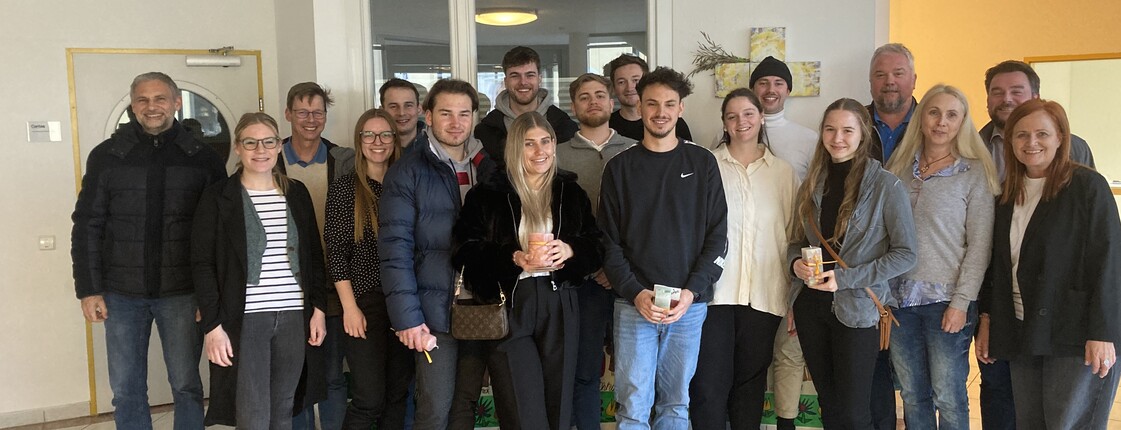 Studierende und Mitarbeiter*innen des Caritas-Zentrums stehen in einem Raum zu einem Gruppenfoto zusammen.
