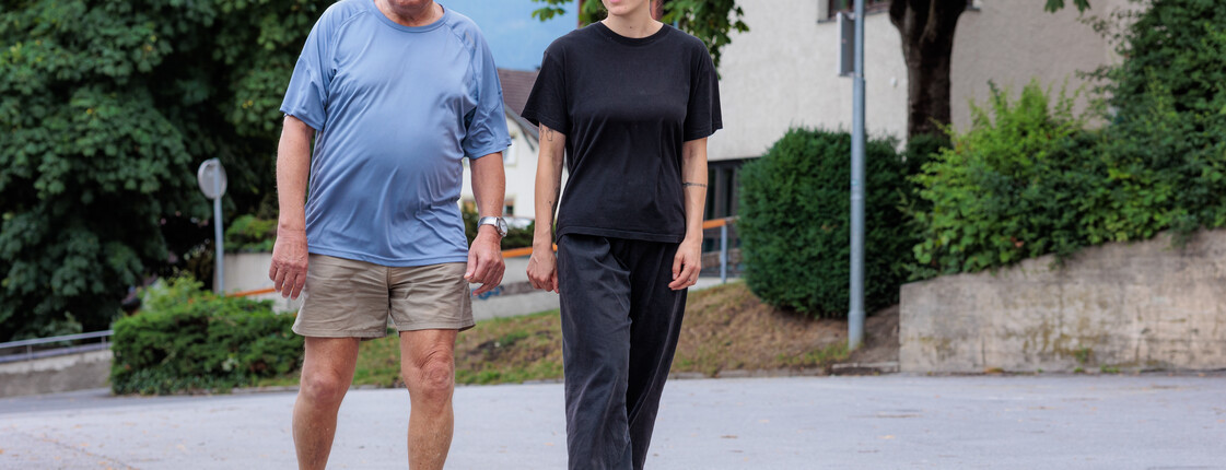 Besuchs- und Begleitdienste Eine Ehrenamtliche begleitet einen Angehörigen regelmäßig bei Spaziergängen in der Nachbarschaft.