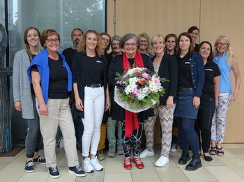 Mitarbeiter*innen der Sozialpädagogischen Familienhilfe der Caritas stehen zu einem Gruppenfoto zusammen.