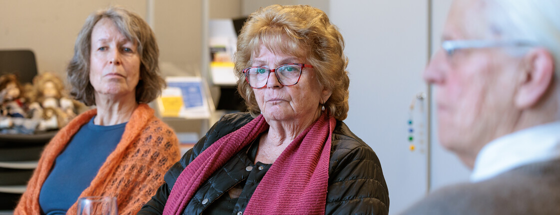 Drei Seniorinnen sitzen während einer Schulung an einem Tisch.