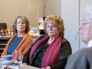 Drei Seniorinnen sitzen während einer Schulung an einem Tisch.