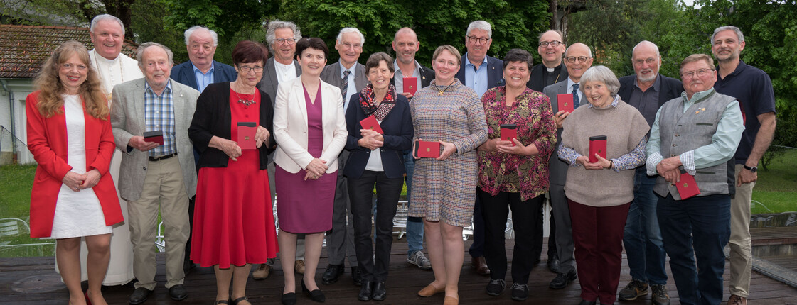 Ein Gruppenfoto mit Personen, die ein Ehrenzeichen erhalten haben.