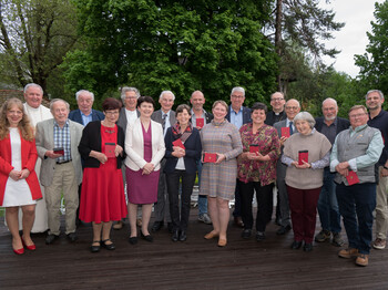 Ein Gruppenfoto mit Personen, die ein Ehrenzeichen erhalten haben.