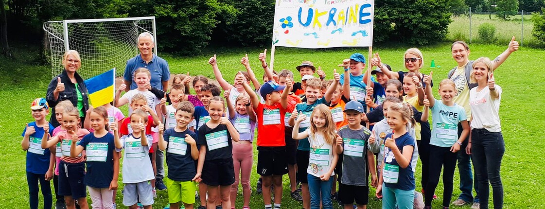 Gruppenfoto einer Klasse mit Lehrpersonal auf einem Fußballfeld.