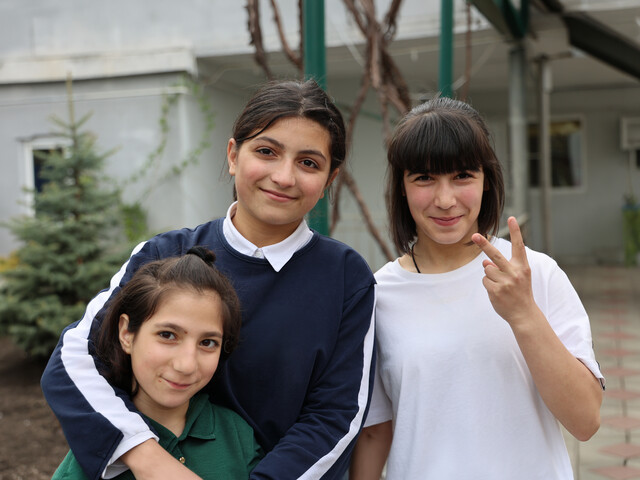 Drei Mädchen in Armenien stehen zu einem Gruppenfoto zusammen.