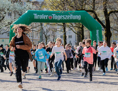 Viele Schüler*innen laufen einem youngCaritas Mitarbeiter hinterher.