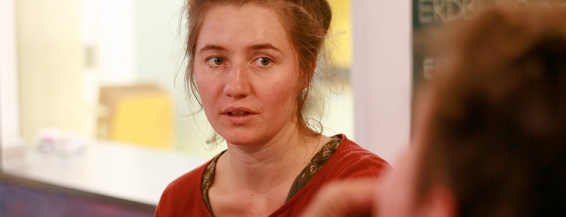 Eine Caritas-Mitarbeiterin ist im Gespräch mit einem Jugendlichen.