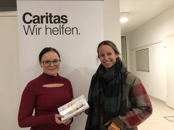 Zwei Frauen stehen vor einenm Roll-Up zu einem Foto zusammen.