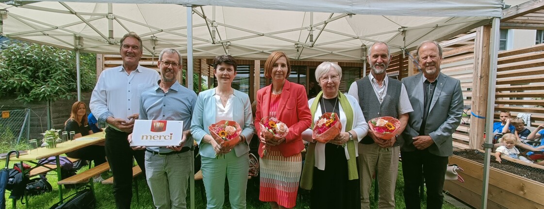 Sieben Personen stehen zu einem Gruppenfoto zusammen.