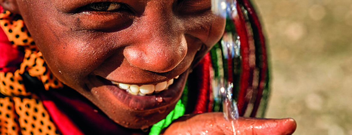 African little girl from Samburu tribe drinking fresh water on savanna., East Africa
