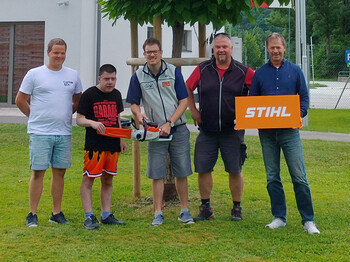 Fünf Personen stehen vor einem Gebäude zu einem Gruppenfoto zusammen.