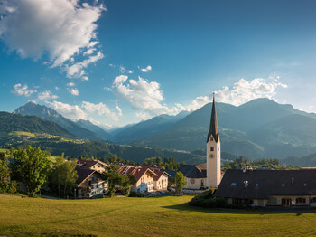 Ein Dorf in Tirol mit Kirchturm.