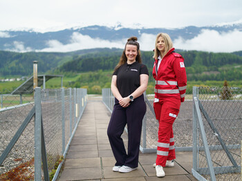 Portrait zweier Frauen mit Bergkulisse im Hintergrund.