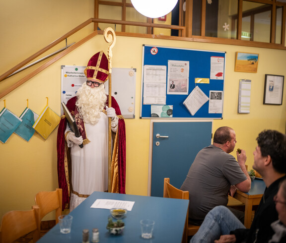 Ein Mann im Nikolaus-Kostüm steht in einem Raum.