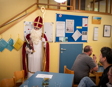 Ein Mann im Nikolaus-Kostüm steht in einem Raum.
