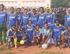 Es ist bemerkenswert, dass fast die Hälfte der Fußballteams bei der Fußballmeisterschaft von Mädchen gebildet wird.  Ein Mädchenfußballteam in blauen Trikots posiert gemeinsam mit Trainern für ein Gruppenfoto.