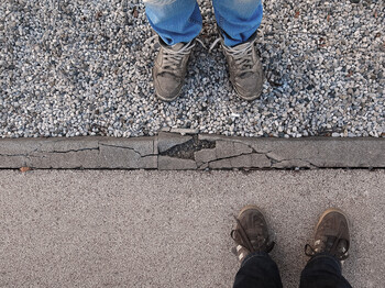 Ein Paar abgetragene Sneaker auf Asphalt.