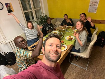 Selfie von sieben Personen, die an einem Tisch sitzen und zu Abend essen.