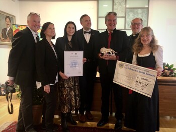 Sieben festlich gekleidete Personen stehen zu einem Gruppenbild zusammen.