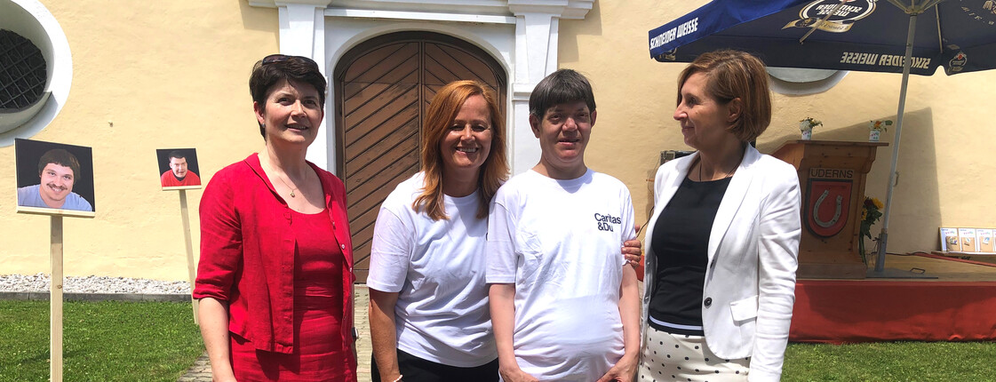 Vier Frauen stehen vor einem Gebäude zu einem Gruppenfoto zusammen.