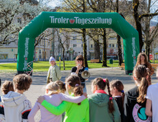 Eine Frau mit Megafon steht vor einer Gruppe Schulkinder.