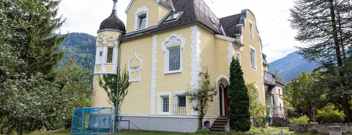 Außenansicht einer großen Gründerzeit-Villa mit Garten.