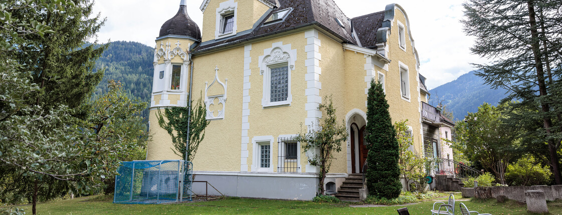Außenansicht einer großen Gründerzeit-Villa mit Garten.
