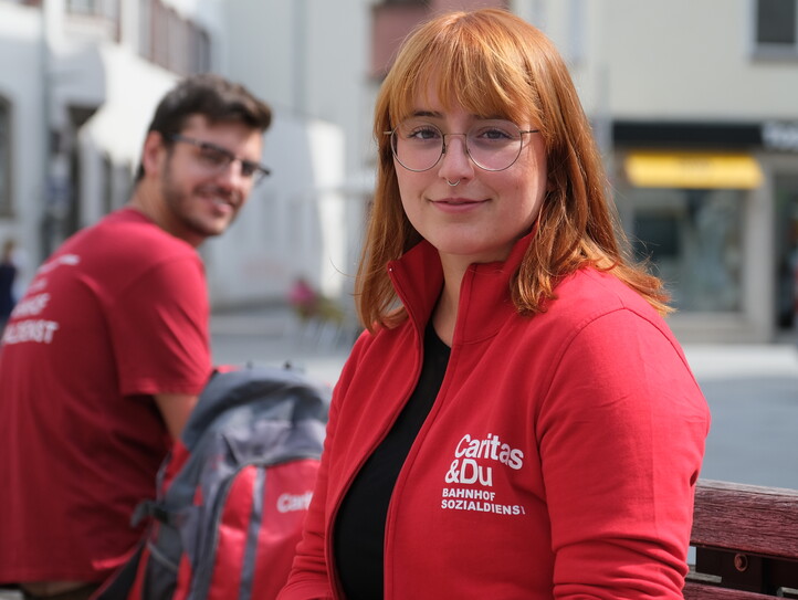 Zwei sitzende Caritas-Mitarbeiter*innen.