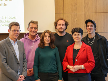 Sechs Personen stehen in zwei Reihen zu einem Gruppenfoto zusammen.