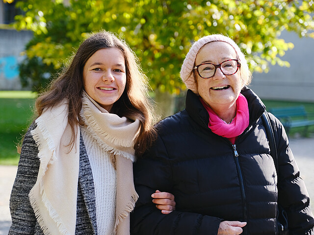Eine junge Frau begleitet eine Pensionistin zu ihrem Arzttermin