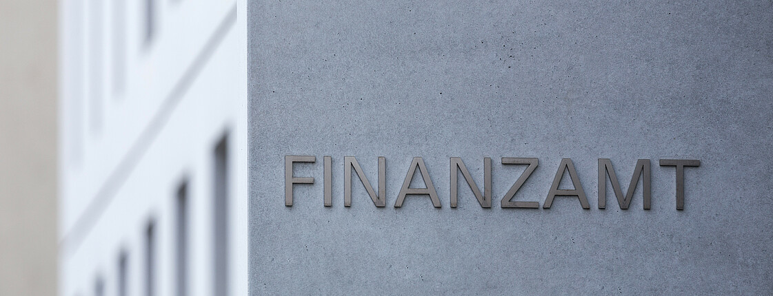 Ein Finanzamt Schild an einem modernen Gebäude.