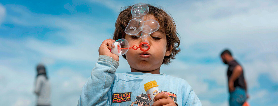 Ein Kind pustet Seifenblasen in die Luft