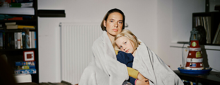 Portrait einer Mutter mit ihrer Tochter im Arm.