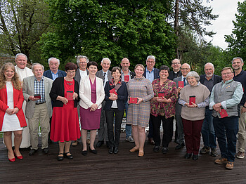 Ein Gruppenfoto mit Personen, die ein Ehrenzeichen erhalten haben.